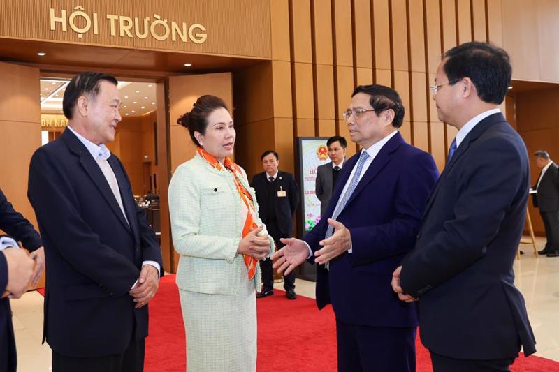 Prime Minister Pham Minh Chinh (second right) speaks with representatives from SOEs on the sidelines of the meeting in Hanoi on March 3.