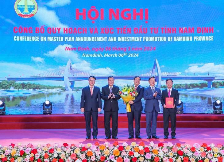 Deputy Prime Minister Tran Hong Ha (second, right) grants the Prime Minister’s decision to approve the provincial master plan to local Nam Dinh authorities at a ceremony on March 6.