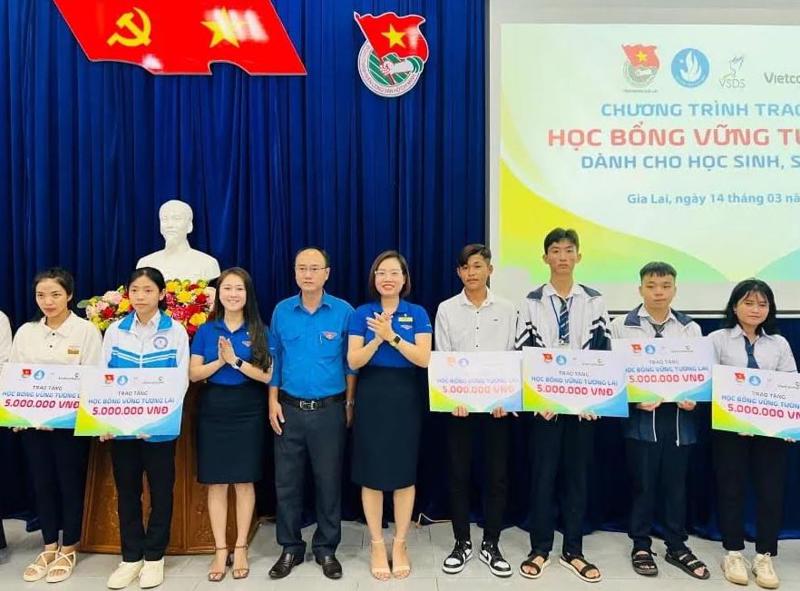 Đồng chí Đinh Thị Mỹ Hạnh - Phó Bí thư Đoàn thanh niên Vietcombank Gia Lai (thứ hai từ phải sang) và đồng chí Bùi Thị Thanh Tuyền - Bí thư Chi đoàn Vietcombank Bắc Gia Lai (thứ hai từ trái sang) trao bảng tượng trưng giá trị tài trợ học bổng “Vững tương lai” cho đại diện Tỉnh đoàn Gia Lai - đồng chí Phan Hồ Giang, Phó Bí thư thường trực (thứ ba từ phải sang).