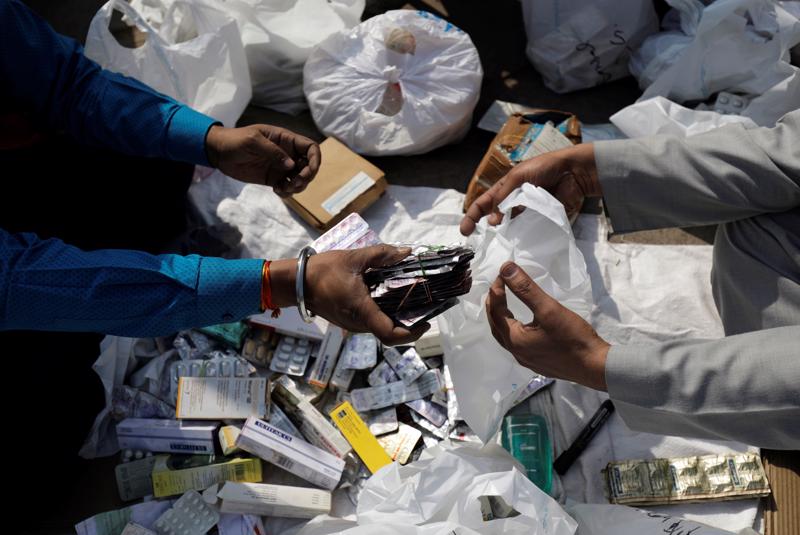 Phân loại thuốc hết hạn tại một hiệu thuốc ở New Dehli - Ảnh: Reuters