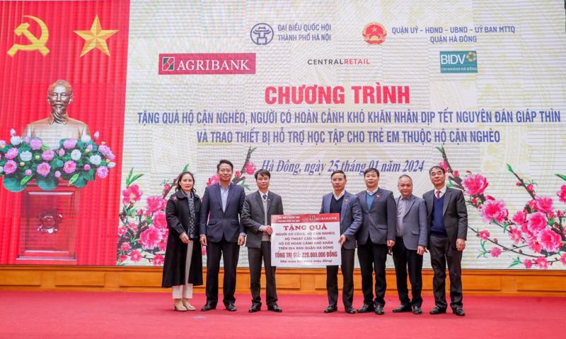 Đồng chí Phạm Đức Ấn - Ủy viên Ban Thường vụ Đảng bộ Khối Doanh nghiệp Trung ương, Bí thư Đảng ủy, Chủ tịch Hội đồng thành viên Agribank trao tặng quà của Agribank hỗ trợ hộ cận nghèo, đối tượng chính sách quận Hà Đông (Hà Nội) nhân dịp Tết Nguyên đán Giáp Thìn.