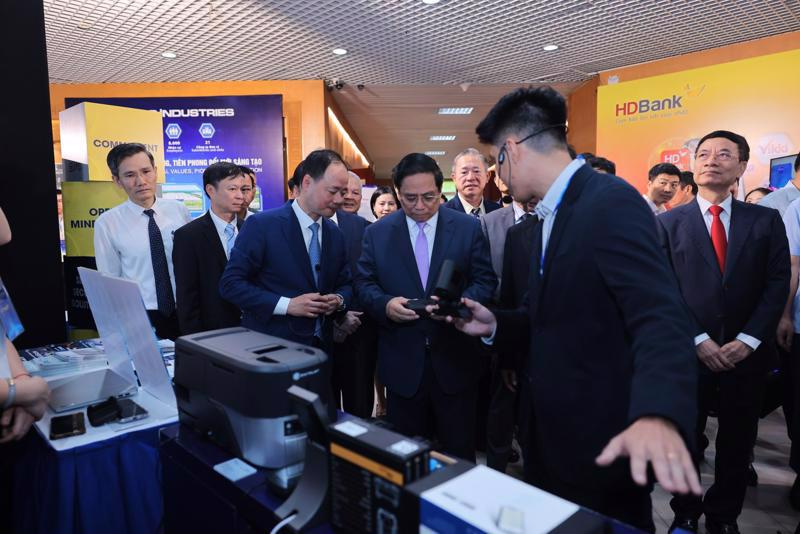 Prime Minister Pham Minh Chinh visits a booth showcasing scientific and technological products on the sidelines of the ceremony. 