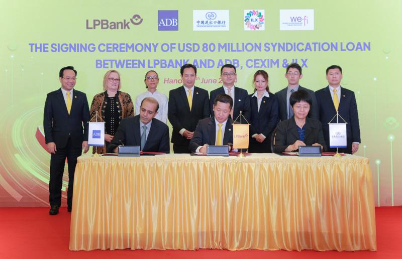 Ông Vũ Quốc Khánh - Phó Tổng giám đốc thường trực LPBank (ngồi giữa) cùng đại diện ADB và các bên liên quan thực hiện ký kết.