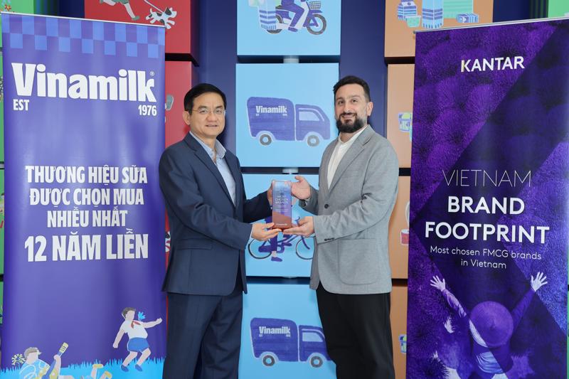 Đại diện Kantar Việt Nam (bên phải) trao các chứng nhận cho ông Nguyễn Quang Trí - Giám đốc điều hành Marketing Vinamilk.