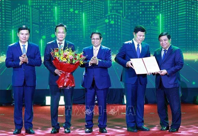 PM Pham Minh Chinh (C) and Minister of Planning and Investment Nguyen Chi Dung (first, R) present the decision approving Hung Yen's master plan to leaders of the province (Photo: VNA)