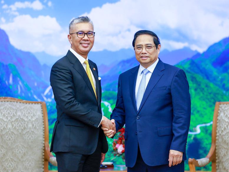 Prime Minister Pham Minh Chinh (right) receiving Malaysian Minister of Investment, Trade and Industry Zafrul Abdul Aziz in Hanoi on July 8. Photo: VGP