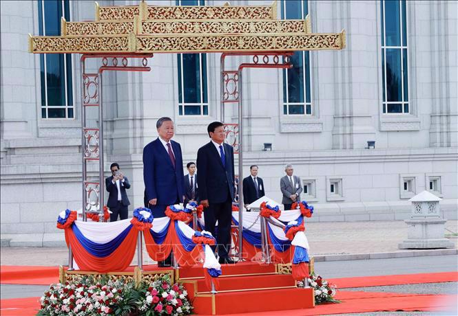 Chủ tịch nước Tô Lâm và Tổng Bí thư, Chủ tịch nước Lào Thongloun Sisoulith trên bục danh dự, nghe quân nhạc cử Quốc thiều hai nước - Ảnh: TTXVN