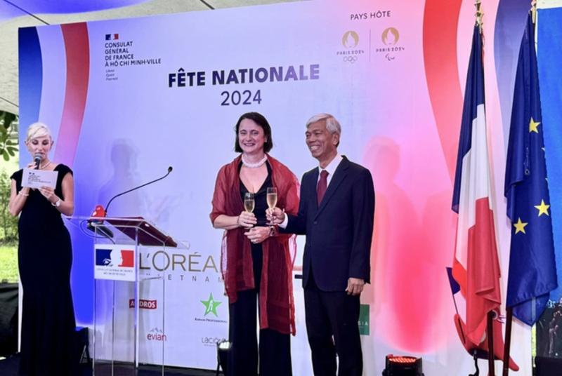 Emmanuelle Pavillon-Grosser, French consul general in HCM City, and Vice Chairman of the municipal People's Committee Vo Van Hoan make a toast at the Bastille Day celebration. 