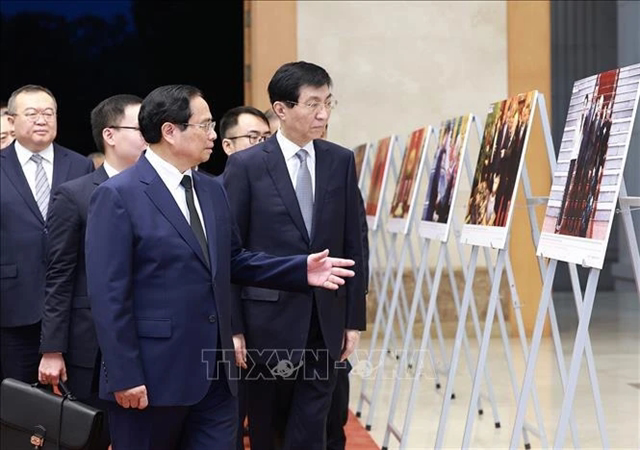 Prime Minister Pham Minh Chinh (1st row, left) introduces Chairman of the Chinese People's Political Consultative Conference (CPPCC) National Committee Wang Huning to photos of some foreign affairs activities of the late Party General Secretary Nguyen Phu Trong. Photo: VNA