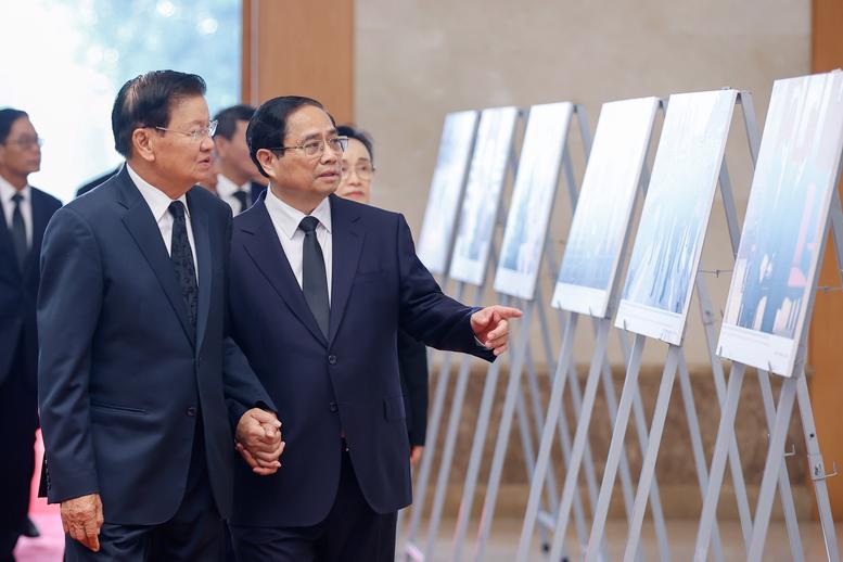 Prime Minister Pham Minh Chinh and General Secretary of the Lao People's Revolutionary Party and President of Laos Thongloun Sisoulith view some photos of Party leader Nguyen Phu Trong's diplomatic activities. Photo: VNA