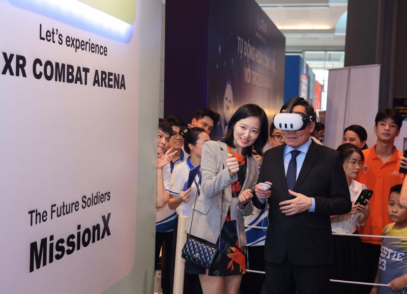 Deputy Prime Minister and Head of the Party Central Committee's Economic Commission Tran Luu Quang experiences virtual reality goggles at the AI expo held as part of the Vietnam AI Day 2024. Photo: VNA