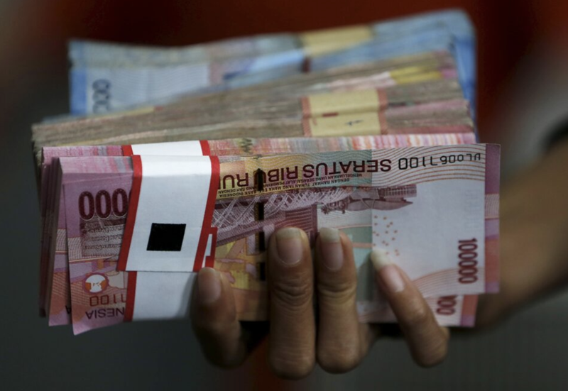 Một xấp tiền rupiah Indonesia - Ảnh: Reuters.