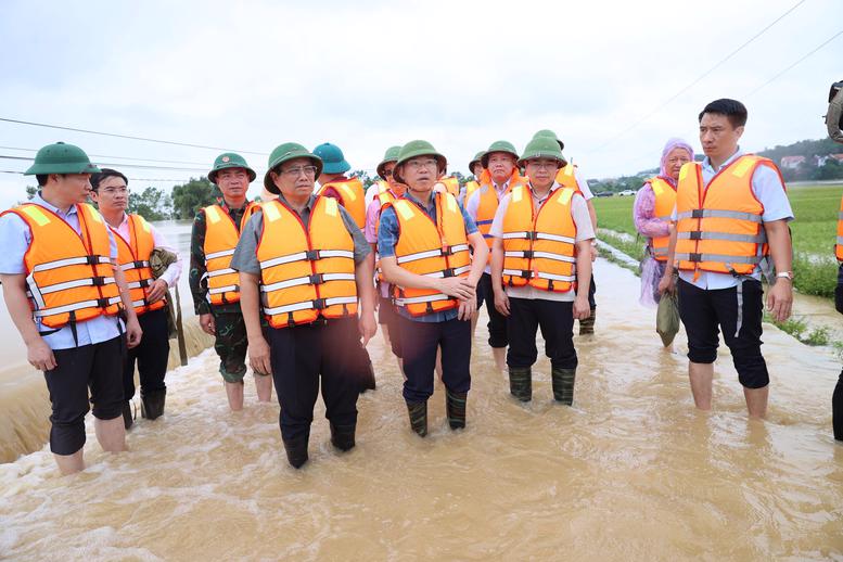 Thủ tướng Phạm Minh Chính thị sát tình hình nước lũ sông Cầu đang tràn bờ khu vực cầu Đá, thôn Hạ Lát, gây ngập lụt cánh đồng xã Tiên Sơn. Ảnh: VGP