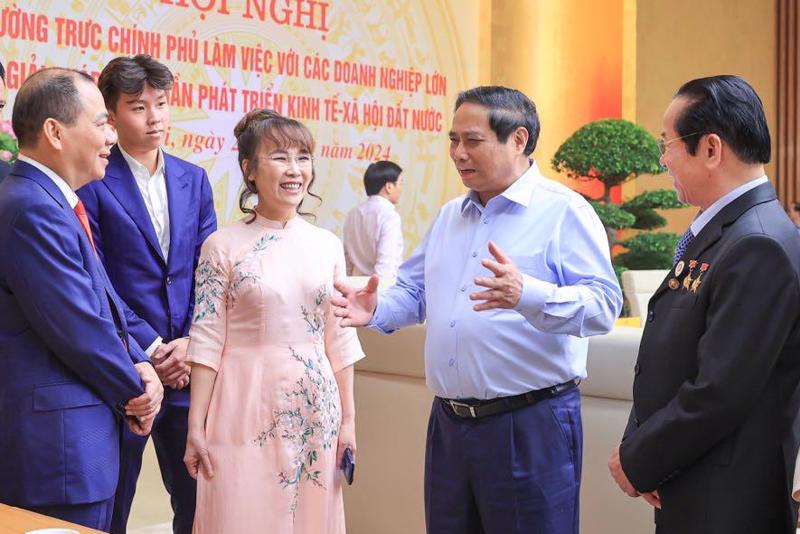 Prime Minister Pham Minh Chinh (second, right) talks to businesses on the sidelines of the meeting.(Photo: VGP)