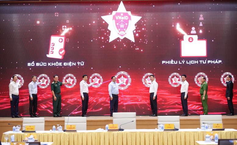 Prime Minister Pham Minh Chinh (center) presses a button to kick start the implementation of the electronic health records and issuance of judicial record certificates via the app VNeID. Photo: VGP