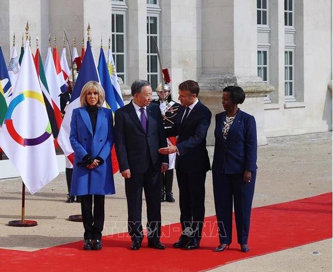 French President Emmanuel Macron and Secretary General of the International Organisation of La Francophonie Louise Mushikiwabo welcome Party General Secretary and State President To Lam (Photo: VNA)