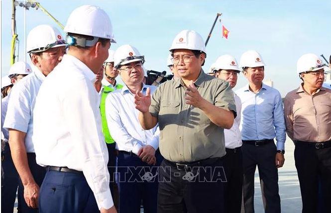 PM Pham Minh Chinh talks to officials while examining the national exhibition and fair centre project in Dong Anh district of Hanoi on October 25. (Photo: VNA)