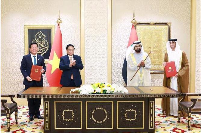 Minister of Industry and Trade Nguyen Hong Dien (left) and UAE Minister of State for Foreign Trade Thani bin Ahmed Al Zeyoudi (right) signed the deal in the witness of Prime Minister Pham Minh Chinh (second from left) and UAE Vice President and Prime Minister Sheikh Mohammed bin Rashid Al Maktoum. (Photo: VNA)