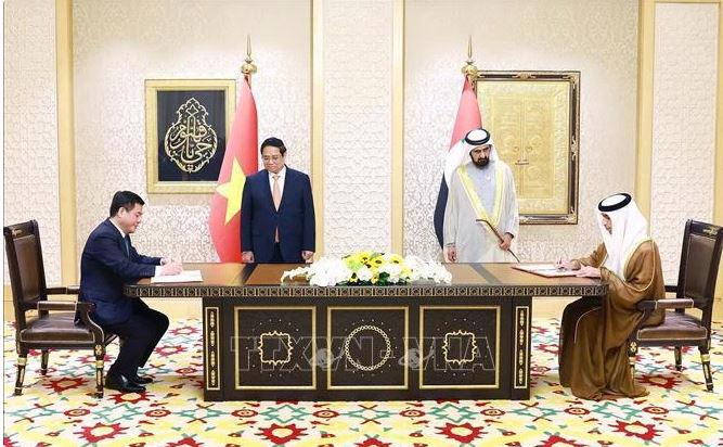 Prime Minister Pham Minh Chinh (left) and Vice President and Prime Minister of the United Arab Emirates (UAE) Sheikh Mohammed bin Rashid Al Maktoum witness the signing of the Comprehensive Economic Partnership Agreement. (Photo: VNA)