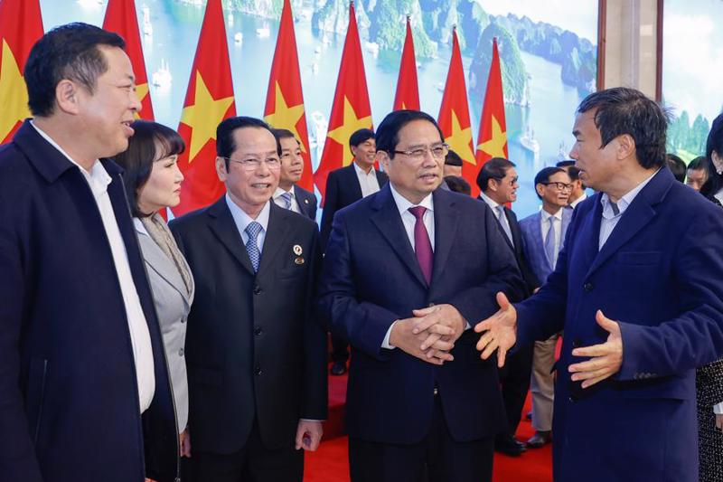 Prime Minister Pham Minh Chinh talking with business leaders on the sidelines of the meeting on February 10.  