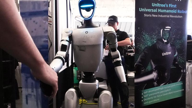 Robot Unitree đang bắt tay người tham dự sự kiện.