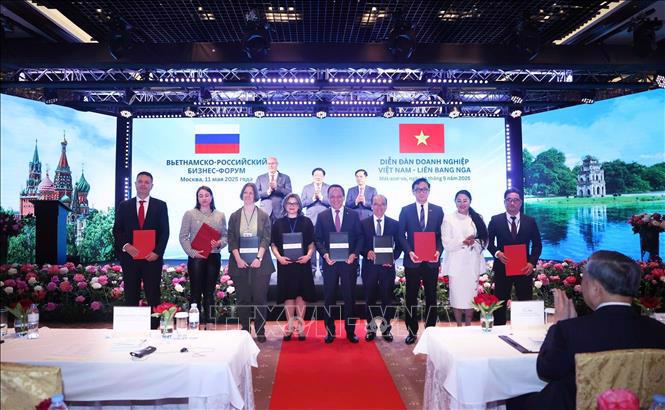Vietnamese and Russian businesses exchange cooperation documents at the forum. Photo: VNA