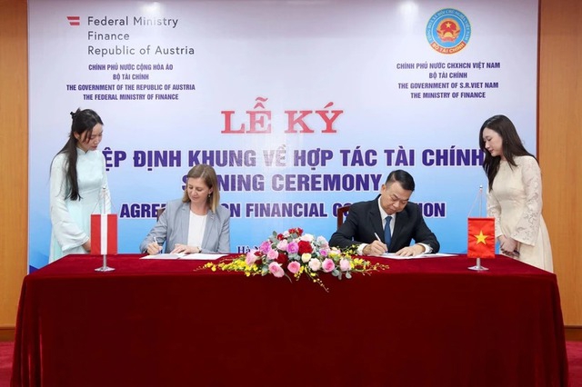 Deputy Minister of Finance Nguyen Duc Chi and State Secretary in the Federal Ministry of Finance Barbara Eibinger-Miedl sign an agreement on financial cooperation in Hanoi, on June 23. (Photo: VNA)