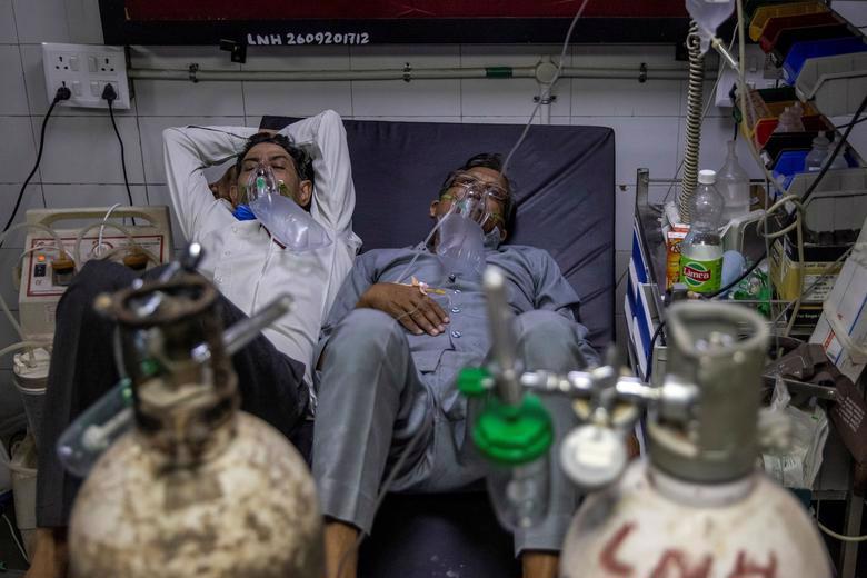 Hai bệnh nh&acirc;n Covid nằm chung giường trong một bệnh viện ở New Delhi - Ảnh: Reuters.