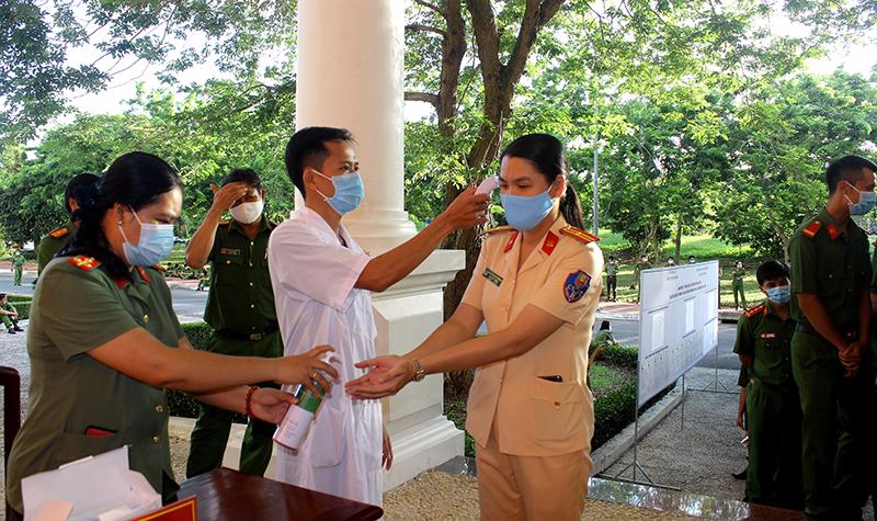 C&aacute;n bộ, chiến sĩ C&ocirc;ng an tỉnh Hậu Giang được kiểm tra th&acirc;n nhiệt, s&aacute;t khuẩn tay trước khi bầu cử - Ảnh: .