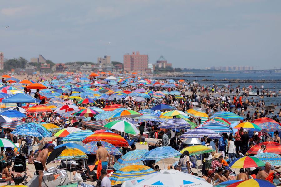 B&atilde;i biển Coney ở th&agrave;nh phố New York đ&ocirc;ng nghẹt du kh&aacute;ch trong kỳ nghỉ Quốc kh&aacute;nh Mỹ - Ảnh: Reuters.