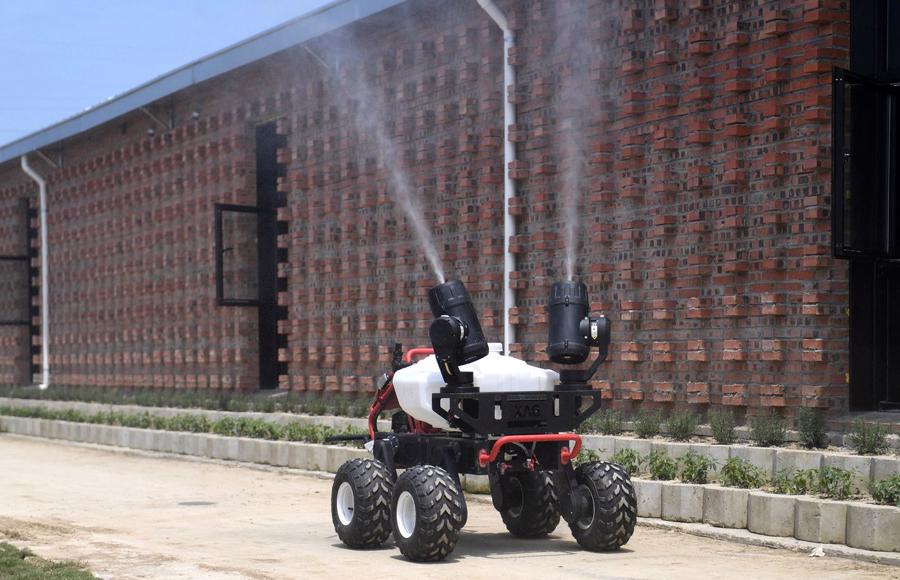 Một robot đang phun khử khuẩn b&ecirc;n ngo&agrave;i một trang trại lợn ở Giang T&acirc;y - Ảnh: Getty/Bloomberg.