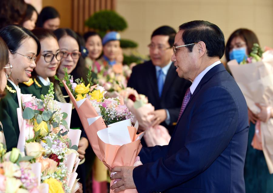 Thủ tướng Phạm Minh Ch&iacute;nh tặng hoa c&aacute;c đại biểu tham dự buổi gặp mặt - Ảnh: VGP