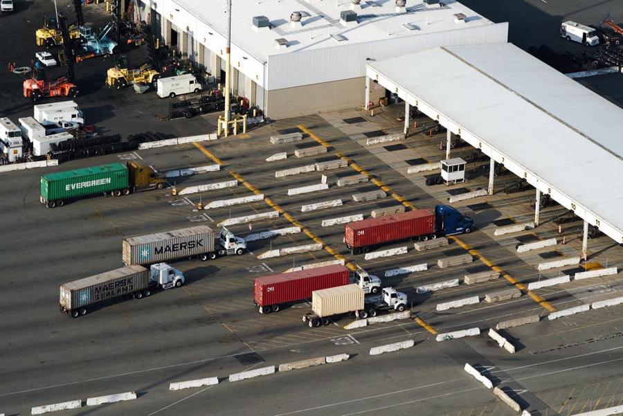 Xe tải chờ để rời khỏi cảng Los Angeles - nơi vẫn chất kin container - Ảnh: Bloomberg