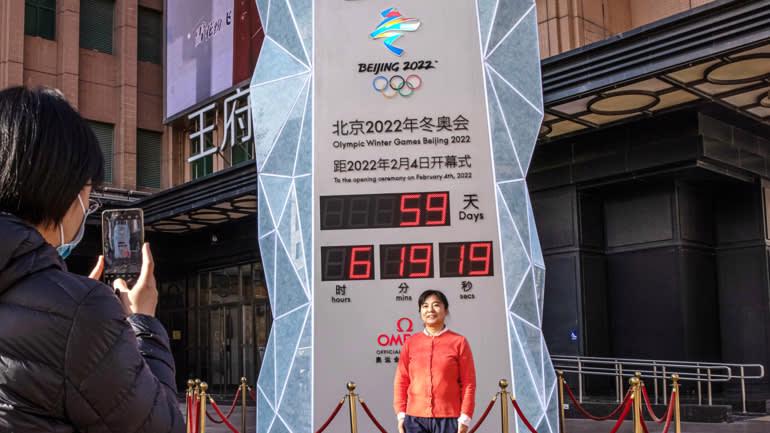 Một phụ nữ ở Bắc Kinh chụp ảnh b&ecirc;n cạnh m&agrave;n h&igrave;nh hiển thị số ng&agrave;y c&ograve;n lại trước Thế vận hội Bắc Kinh 2022. Ng&agrave;y 7/12, Mỹ tuy&ecirc;n bố tẩy chay ngoại giao với sự kiện thể thao n&agrave;y do vấn đề nh&acirc;n quyền ở T&acirc;n Cương. Thế vận hội Bắc Kinh 2022 dự kiến diễn ra từ ng&agrave;y 4-20/2/2022 - Ảnh: EPA