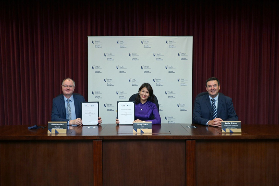SMU Provost Prof Timothy Clark and VIETSTAR CEO, Ms. Pham Thi Thu Hang, holding up the signed MOU. Also present at the event is Mr Eddie Tritton, Executive Director of SMU Executive Development.