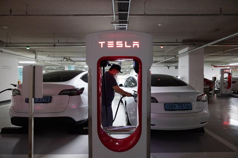 Một t&agrave;i xế sạc xe điện Tesla Model 3tại một trạm sạc ở Suwon, H&agrave;n Quốc - Ảnh: Bloomberg
