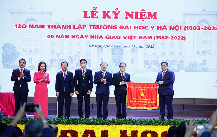 Thủ tướng Phạm Minh Ch&iacute;nh trao Cờ thi đua của Ch&iacute;nh phủ cho Trường Đại học Y H&agrave; Nội. Ảnh: TTXVN