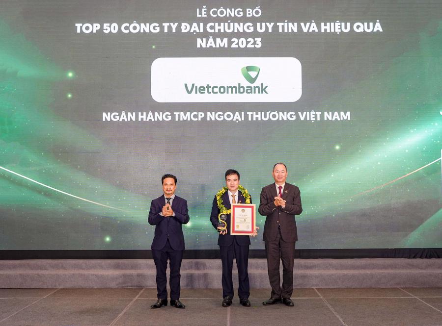 Đại diện Vietcombank (đứng giữa) nhận danh hiệu &ldquo;C&ocirc;ng ty đại ch&uacute;ng uy t&iacute;n v&agrave; hiệu quả nhất Việt Nam năm 2023&rdquo; từ Ban Tổ chức.