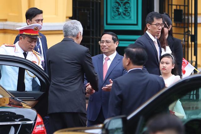 Thủ tướng Phạm Minh Ch&iacute;nh đ&oacute;n Thủ tướng Singapore L&yacute; Hiển Long tại xe - Ảnh: VGP/Nhật Bắc.