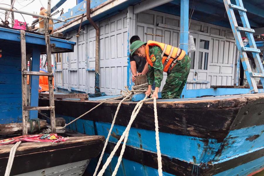 C&aacute;n bộ Đồn Bi&ecirc;n ph&ograve;ng cửa khẩu cảng Thuận An hỗ trợ ngư d&acirc;n gia cố, neo đậu t&agrave;u thuyền. Ảnh: V&otilde; Tiến