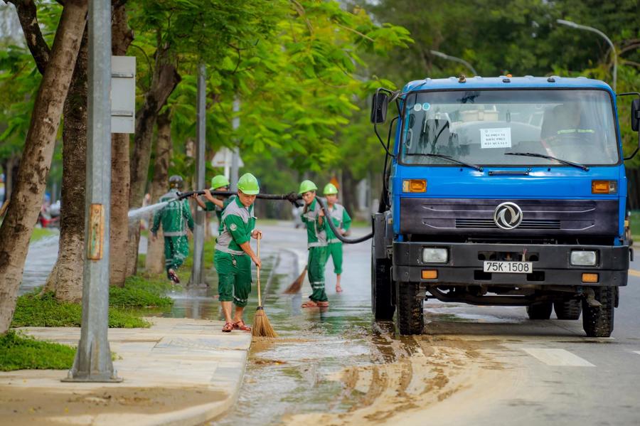 C&aacute;c c&ocirc;ng nh&acirc;n vệ sinh m&ocirc;i trường dọn dẹp b&ugrave;n đất tr&ecirc;n c&aacute;c tuyến đường phố Huế.