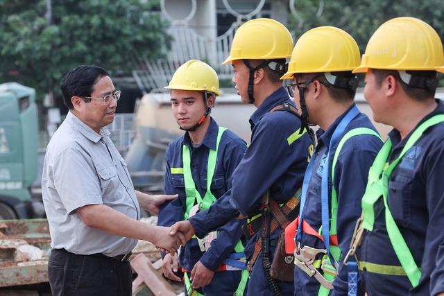 The Prime Minister talked to and encouraged workers working at the Nguyen Hoang Street project and the new bridge across the Huong River - (Photo: VGP/Nhat Bac)