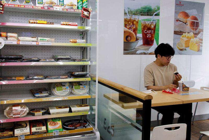 Một nh&acirc;n vi&ecirc;n văn ph&ograve;ng ăn trưa tại một cửa h&agrave;ng tiện lợi ở Seoul, H&agrave;n Quốc - Ảnh:&nbsp;Reuters