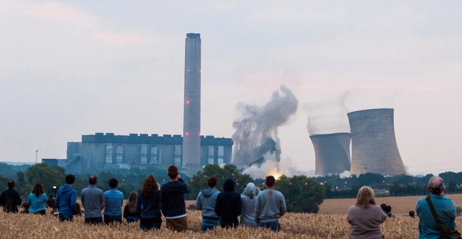 People watch the demolition of the iconic cooling towers of Didcot A power station, Oxfordshire, England, in 2014. Photo: ajsissues /Alamy Stock Photo.