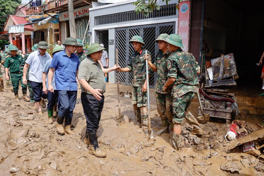 Thủ tướng hỏi thăm c&aacute;c đơn vị C&ocirc;ng an đang gi&uacute;p d&acirc;n khắc phục hậu quả mưa lũ - Ảnh: VGP