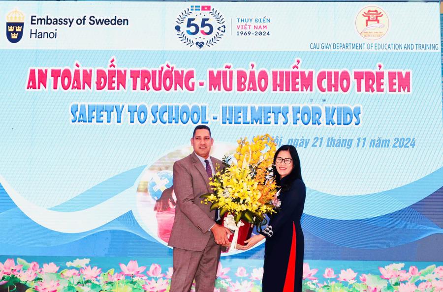 Ms. Trinh Thi Dung, Vice Chairwoman of the Cau Giay District People&rsquo;s Committee, presents flowers to Swedish Ambassador Johan Ndisi.