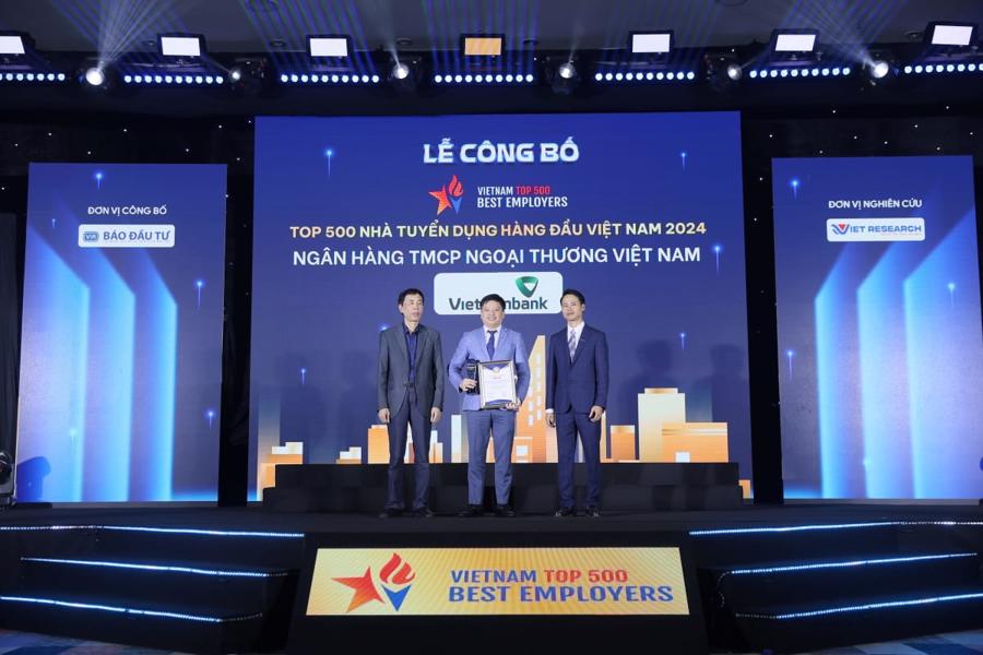 Đại diện Vietcombank, &ocirc;ng Nguyễn Ki&ecirc;n Hiếu - Ph&oacute; Trưởng Ban Tổ chức &amp; Nh&acirc;n sự (giữa) nhận giải thưởng &ldquo;Top 500 nh&agrave; tuyển dụng h&agrave;ng đầu Việt Nam năm 2024&rdquo;.