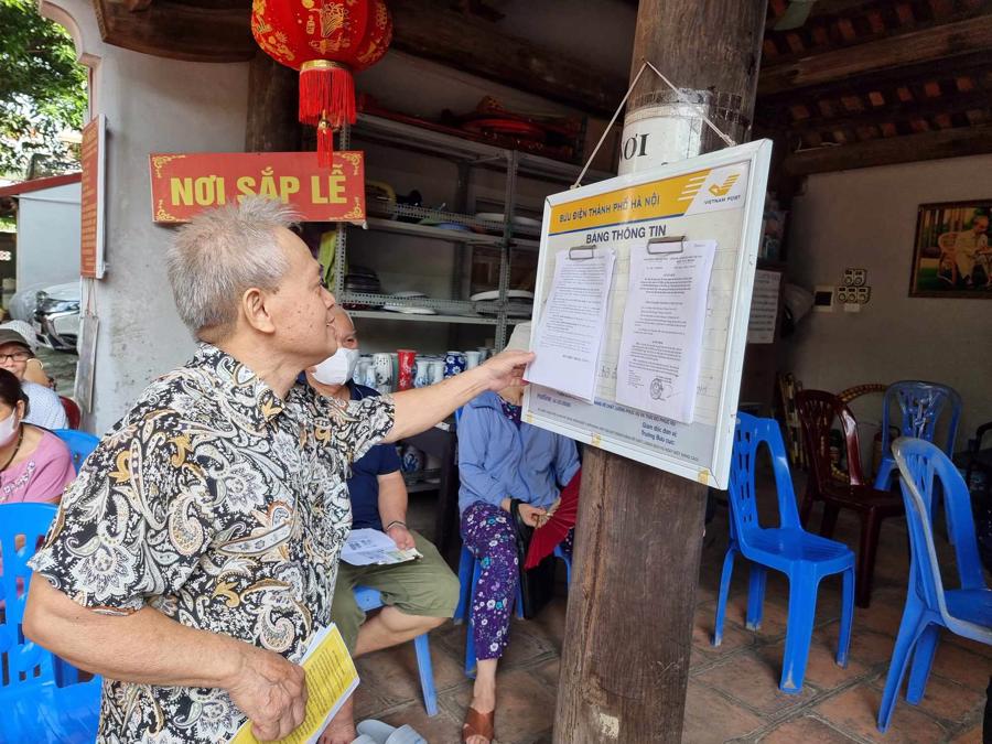 Người hưởng theo d&otilde;i th&ocirc;ng tin về lịch chi trả. Ảnh: Xu&acirc;n Minh.