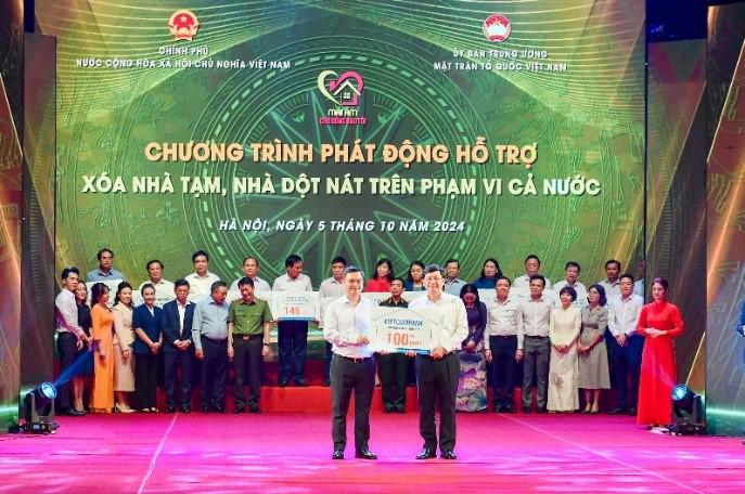 &Ocirc;ng Nguyễn Thanh T&ugrave;ng, B&iacute; thư Đảng uỷ, Chủ tịch HĐQT Vietcombank (b&ecirc;n tr&aacute;i), trao tượng trưng kinh ph&iacute; 100 tỷ đồng hỗ trợ xo&aacute; nh&agrave; tạm, nh&agrave; dột n&aacute;t ủng hộ cho địa phương.