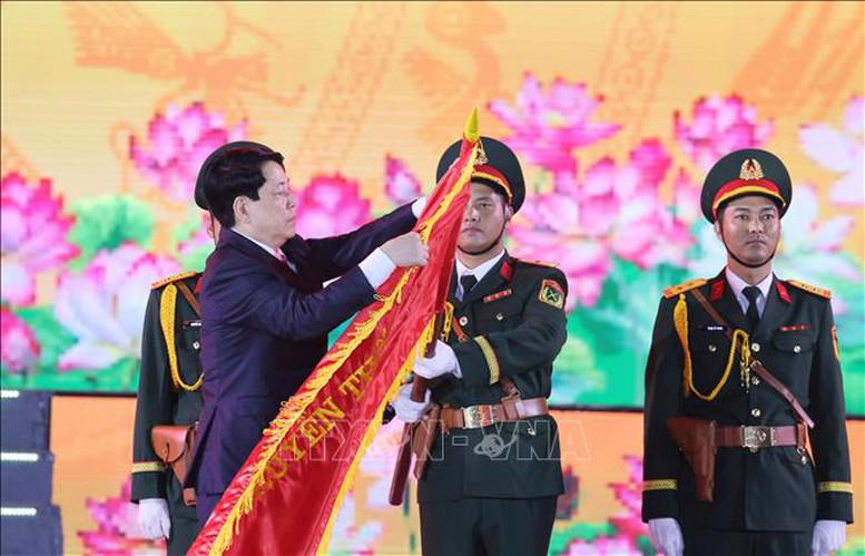 Chủ tịch nước Lương Cường gắn Huy hiệu Thành phố Anh hùng lên lá cờ truyền thống của Đảng bộ, chính quyền và nhân dân Thành phố Hải Phòng. Ảnh: TTXVN